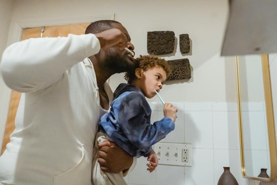 Image of a child brushing their teeth with guidance from a parent, emphasizing the importance of proper tooth brushing techniques for maintaining oral health.